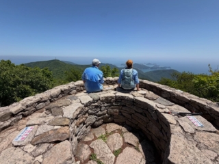 My last two days with my guests Neil and Wanda from Australia were spent in Namhae, Sachon and across to Busan through the island archipelago of Tongyong and Geoje. It was a perplexing way to end a mountain tour on the south coast of Korea surrounded by islets, sea, villages, bridges, energy and peaks - jutting on the silver-blue metallic sea arcing on the horizon. Seeing Korea in May, especially the mountains, towns and valleys, in good weather is a real marvel. Everything shines. Plying our way in the traffic to Hyundae beach in Busan, seeing the California style ease of this area, is not a bad way to reflect about the interior. Why not? Chur.