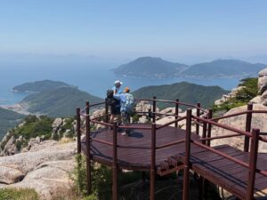 My last two days with my guests Neil and Wanda from Australia were spent in Namhae, Sachon and across to Busan through the island archipelago of Tongyong and Geoje. It was a perplexing way to end a mountain tour on the south coast of Korea surrounded by islets, sea, villages, bridges, energy and peaks - jutting on the silver-blue metallic sea arcing on the horizon. Seeing Korea in May, especially the mountains, towns and valleys, in good weather is a real marvel. Everything shines. Plying our way in the traffic to Hyundae beach in Busan, seeing the California style ease of this area, is not a bad way to reflect about the interior. Why not? Chur. My last two days with my guests Neil and Wanda from Australia were spent in Namhae, Sachon and across to Busan through the island archipelago of Tongyong and Geoje. It was a perplexing way to end a mountain tour on the south coast of Korea surrounded by islets, sea, villages, bridges, energy and peaks - jutting on the silver-blue metallic sea arcing on the horizon. Seeing Korea in May, especially the mountains, towns and valleys, in good weather is a real marvel. Everything shines. Plying our way in the traffic to Hyundae beach in Busan, seeing the California style ease of this area, is not a bad way to reflect about the interior. Why not? Chur.
